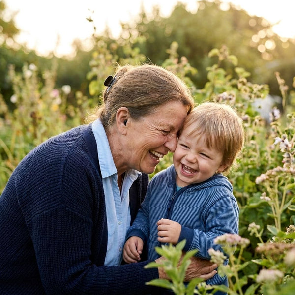 Grandmother and grandchild laughing in a garden